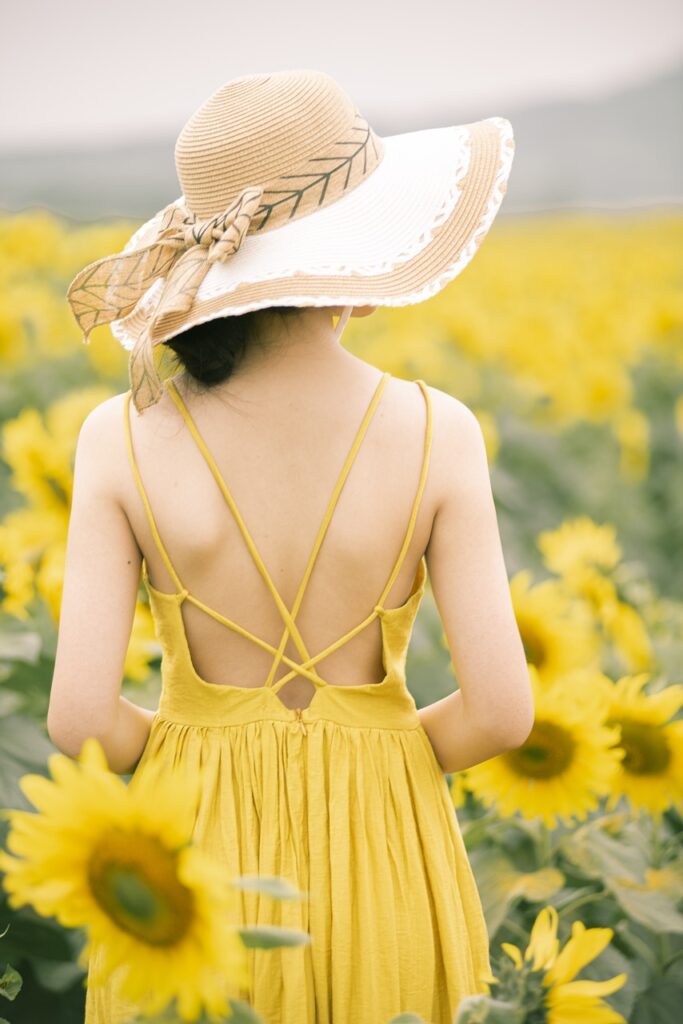 woman with hat in field of daisys